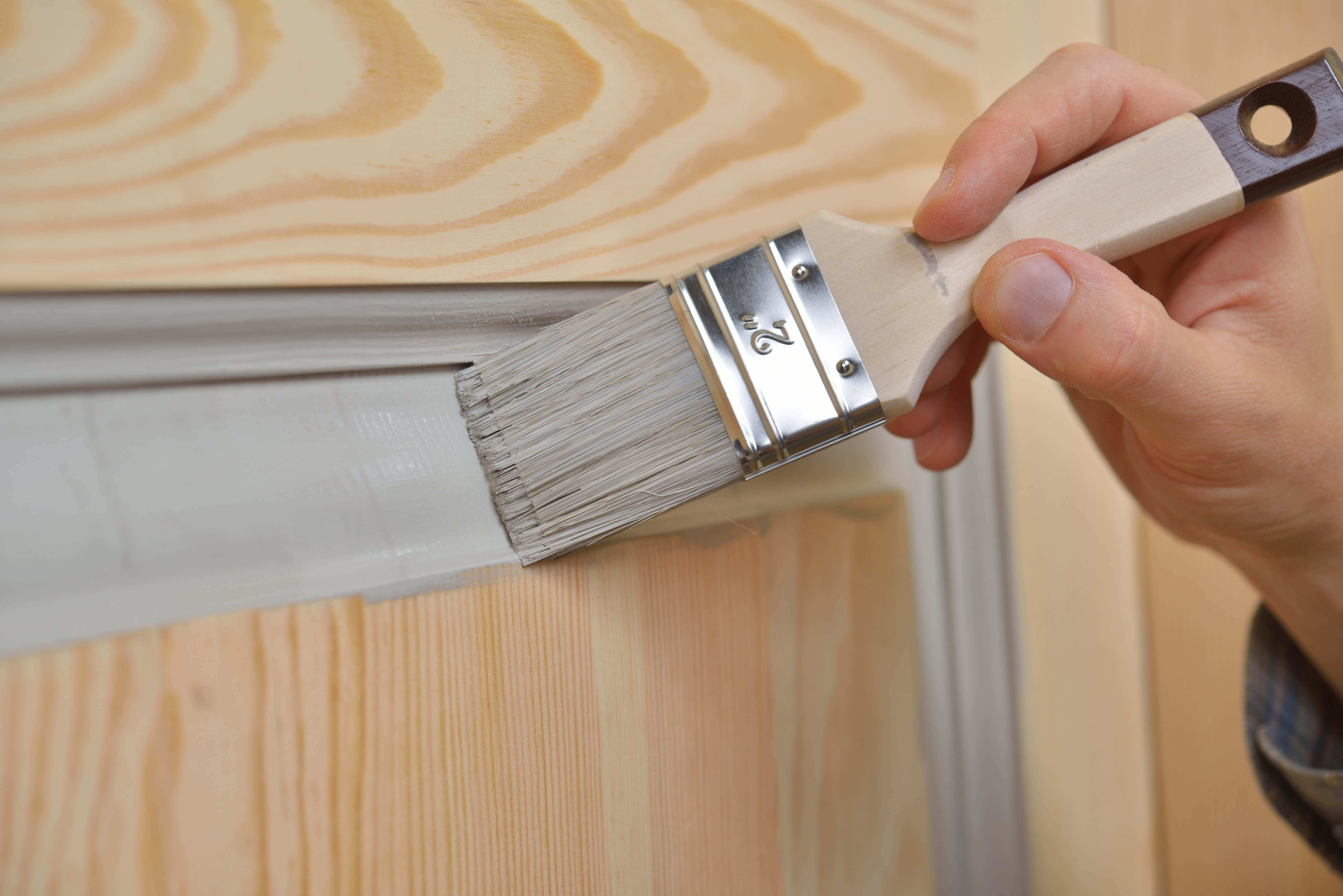 Painting paneled door gray with a paintbrush 